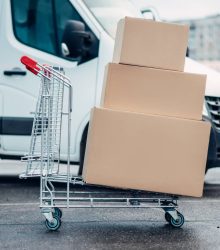 Trolley with carton boxes against truck . Distribution business. Cargo delivery. Empty, clear containers. Mail logistic and post service